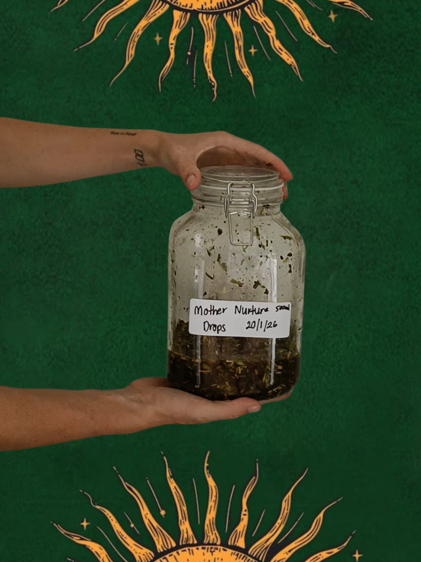 Hand holding a jar labeled 'Mother nuture' against a green background with sun designs.